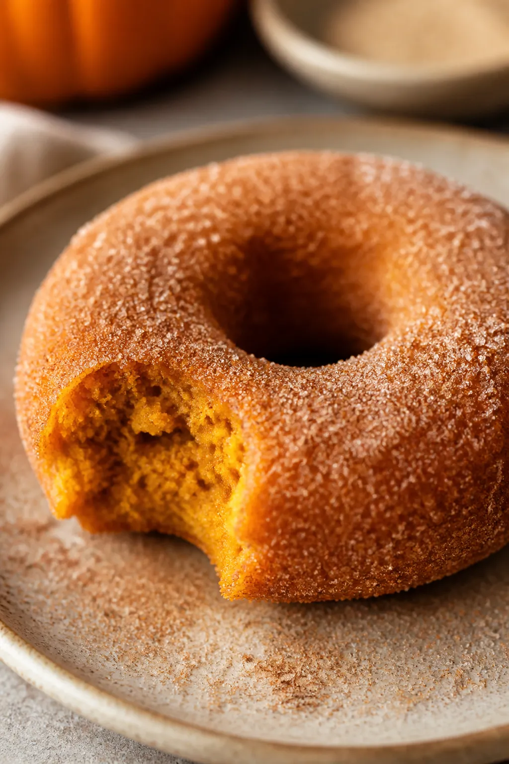 Close-up detail: A warm pumpkin spice donut just brushed with melted butter and freshly coated in sp