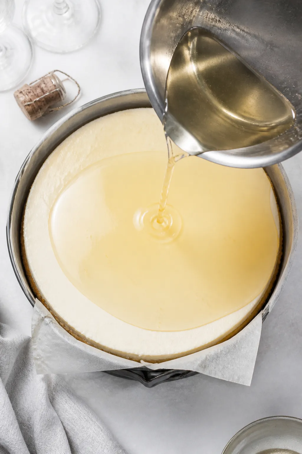 Cooking process: Overhead shot as a clear, lukewarm champagne-gelatin topping is being poured from a