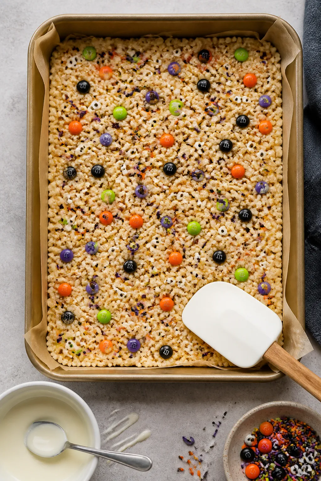 Cooking process: Overhead shot of freshly pressed Rice Krispie mixture in a parchment-lined 9x13 pan