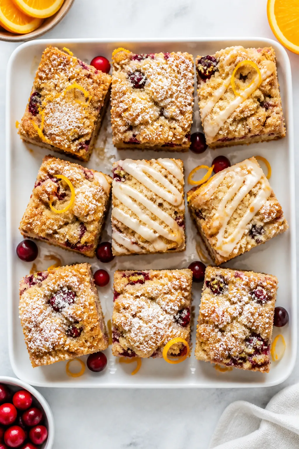 Final dish presentation: Bakery-style squares of cranberry orange crumb cake neatly sliced and sligh