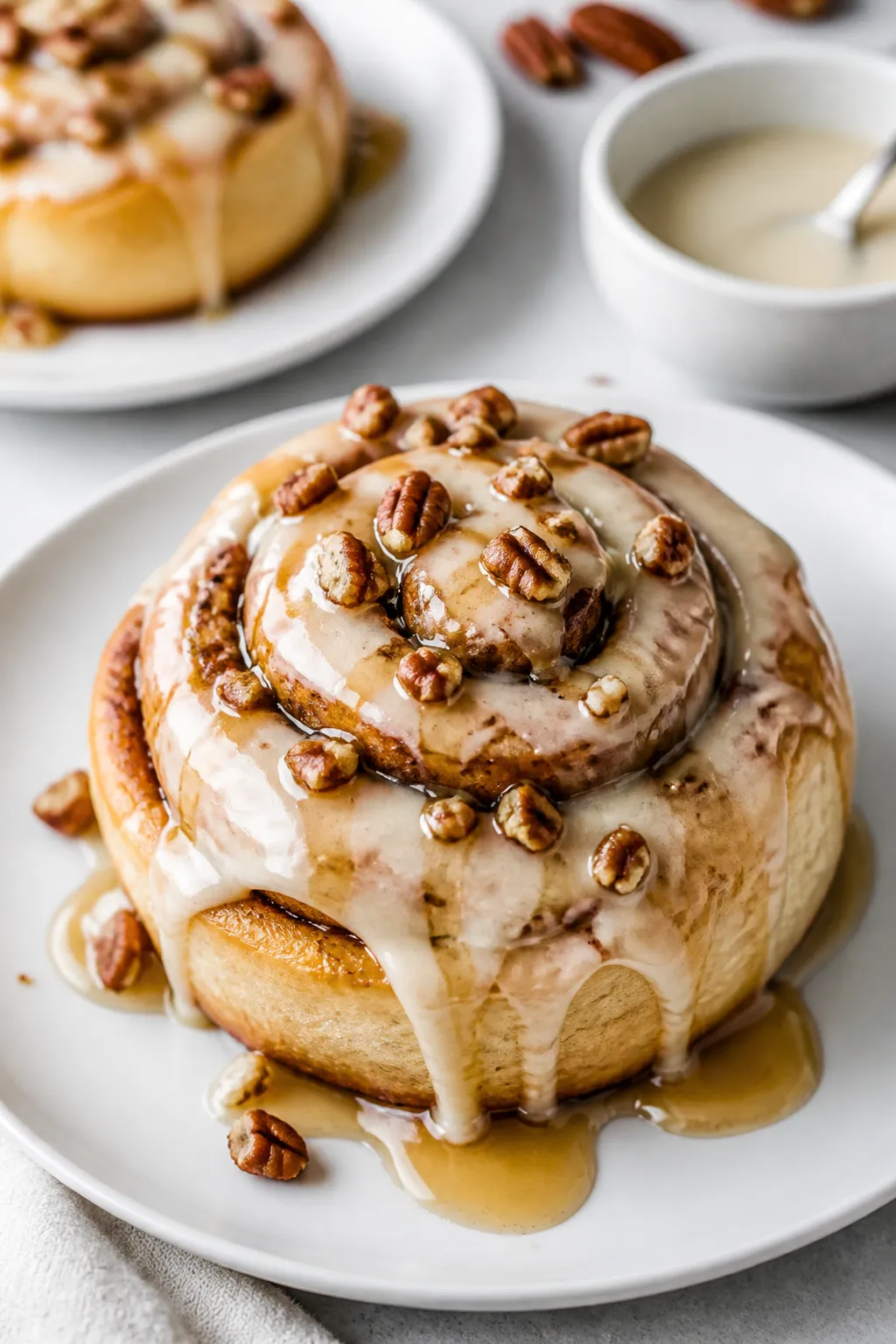 Final dish presentation: Beautifully plated maple pecan cinnamon roll on a matte white plate, genero