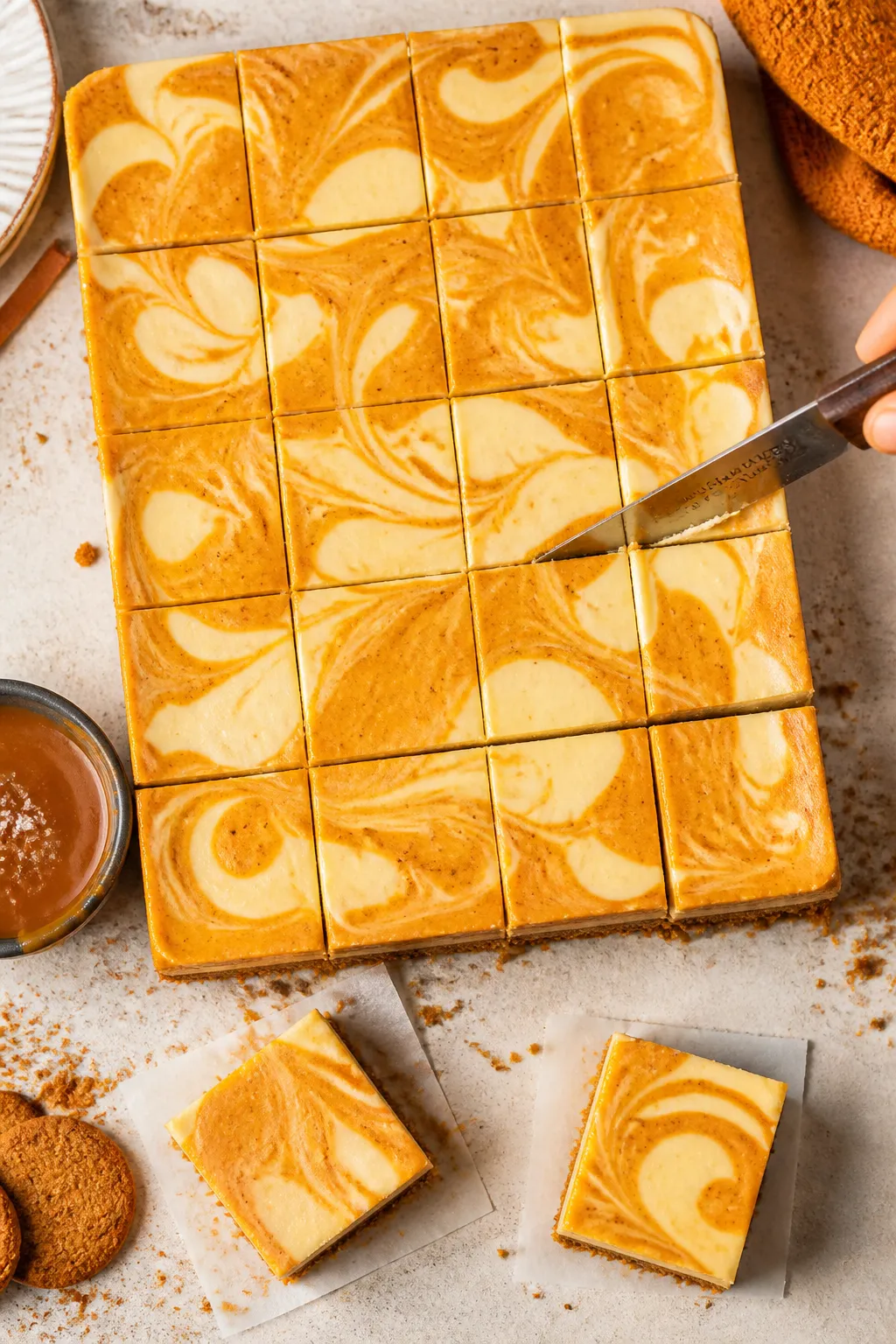 Tasty top view: Overhead shot of a 9x13 tray of fully chilled pumpkin cheesecake bars being cleanly 