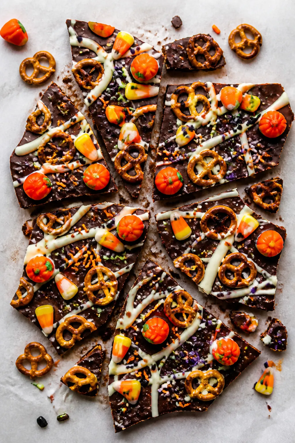 Tasty top view: Overhead shot of fully set Halloween Chocolate Pretzel Bark on parchment, broken int