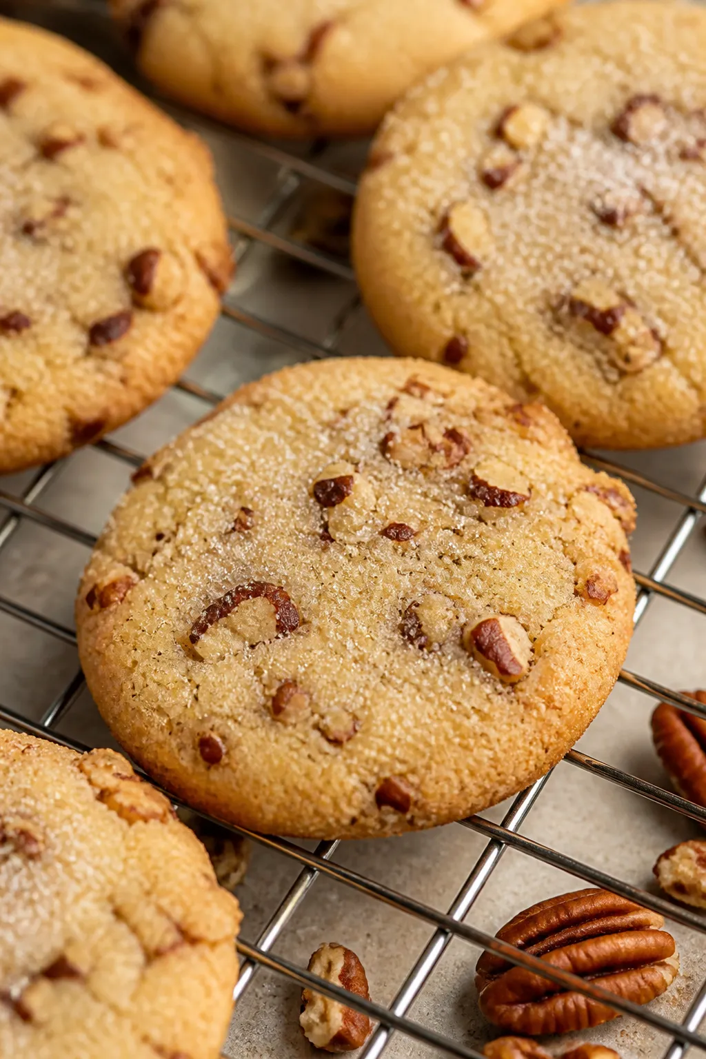 Close-up detail of freshly baked brown sugar pecan shortbread cookies cooling on a wire rack, edges 