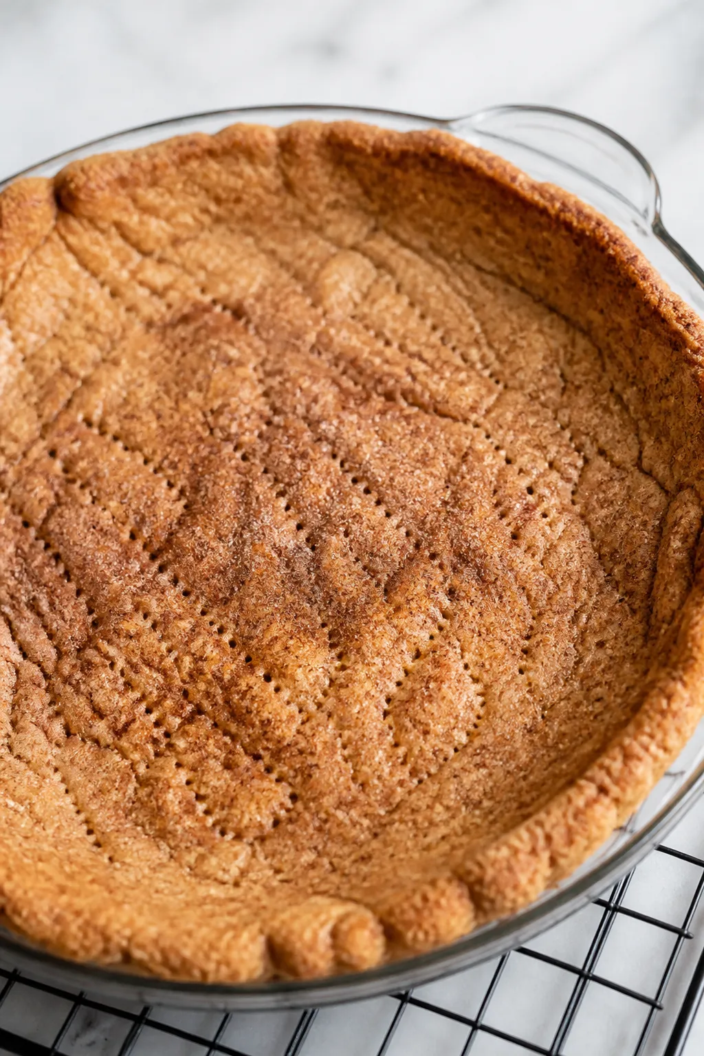 Close-up detail shot of the snickerdoodle-style cookie crust after blind bake, still in a 9-inch pie