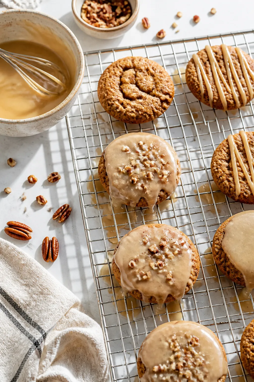 Cooking process: Maple glaze being drizzled in slow ribbons over cooled cookies on a wire rack, thic