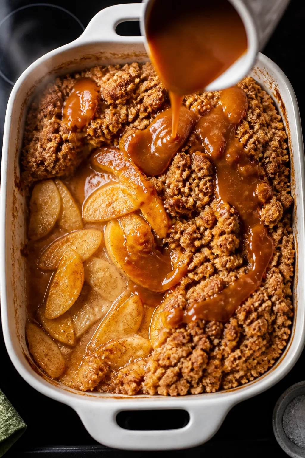 Cooking process: Overhead shot of the crumble in the baking dish mid-sauce step—juicy, tender appl