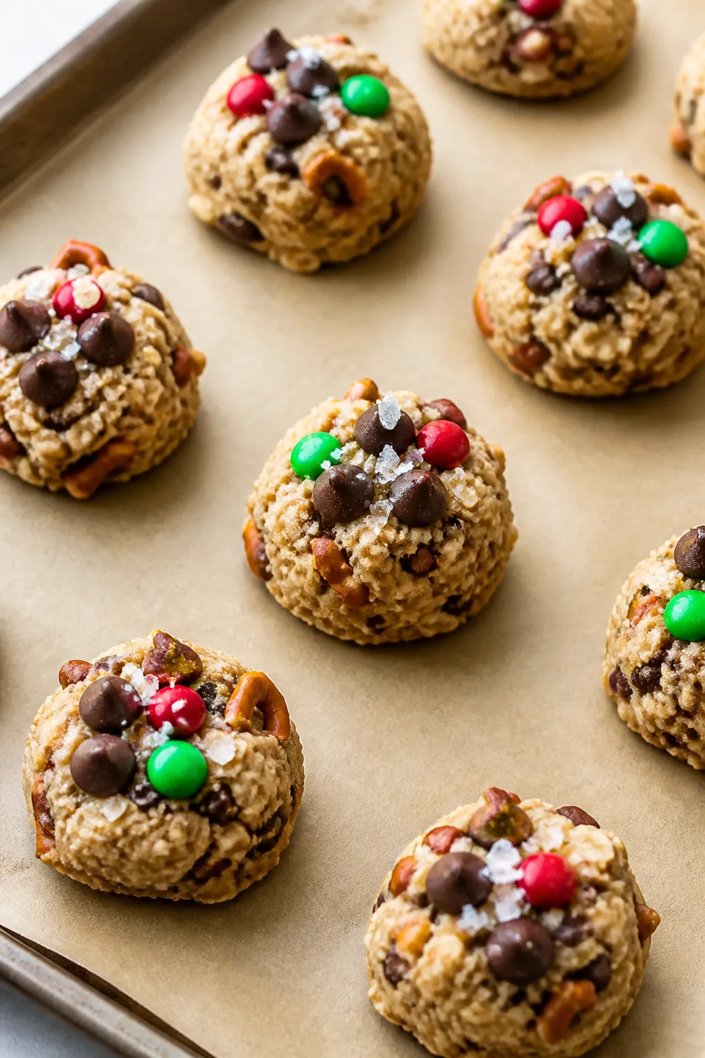 Process shot: scooped, chilled dough balls of Christmas Kitchen Sink Cookies arranged evenly on a pa